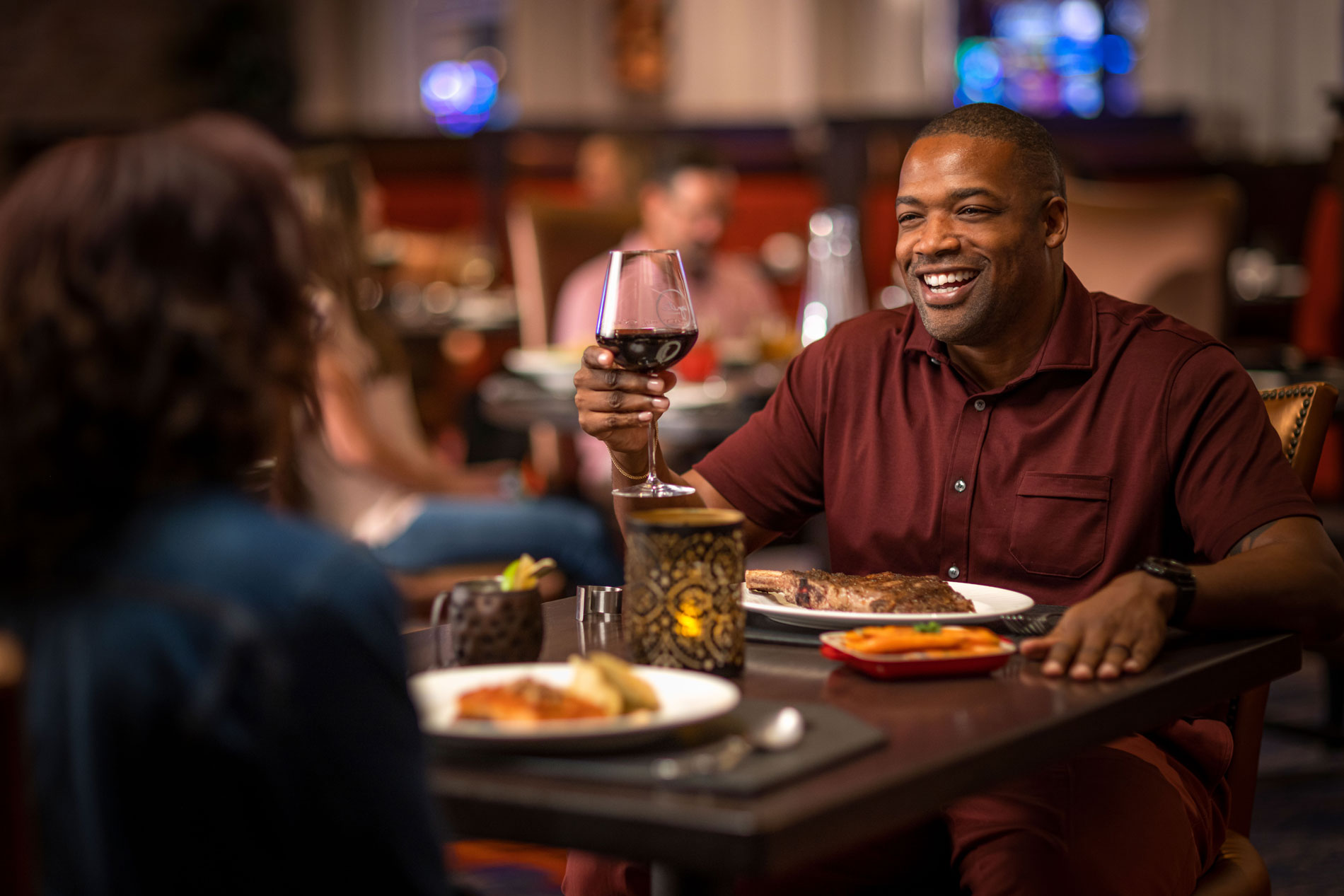 Man raising wine glass at dinner